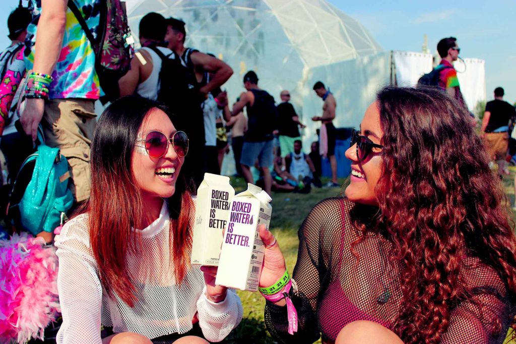 two women enjoying water outside at a concert