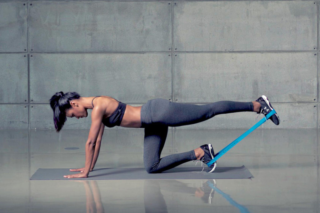 woman doing kickback with resistance band