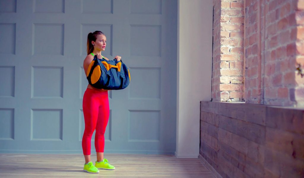 woman workout out with a sandbag