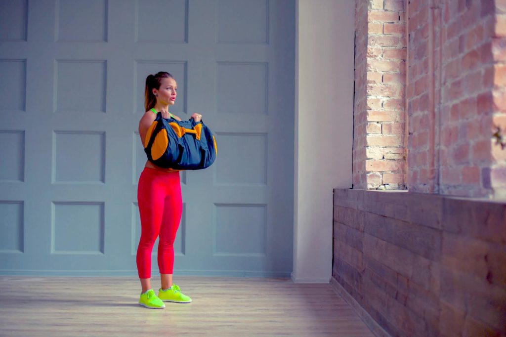 woman workout out with a sandbag