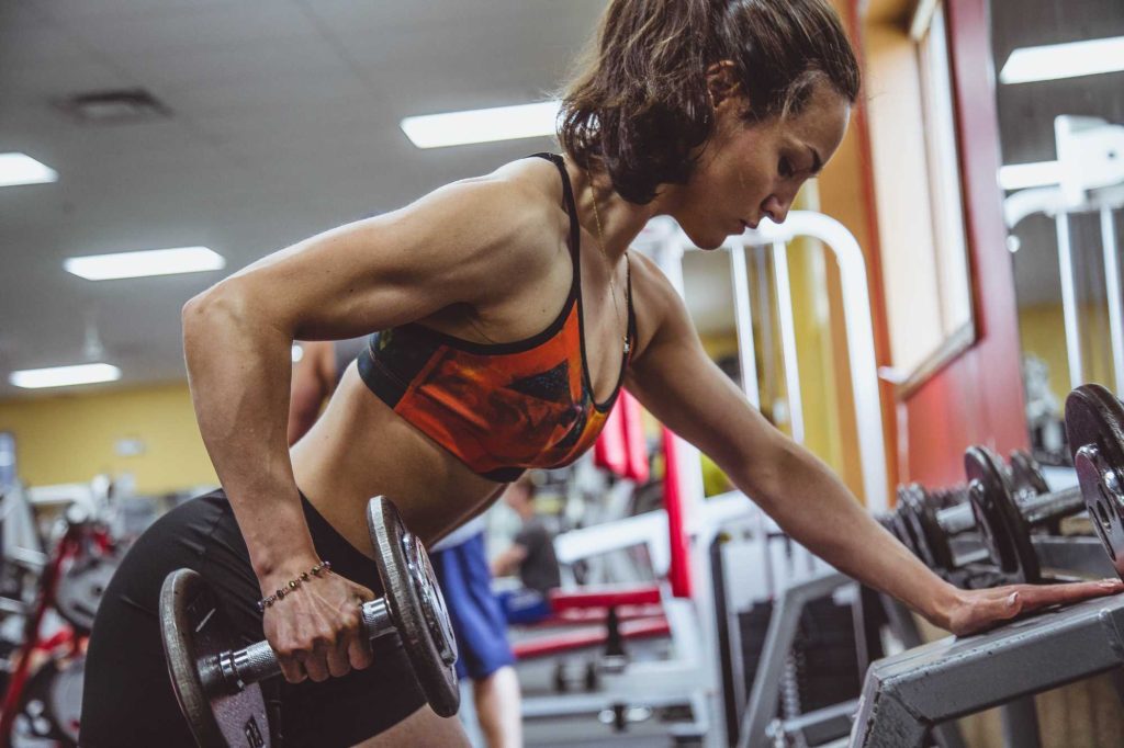 woman doing tricep extensions with dumbbell