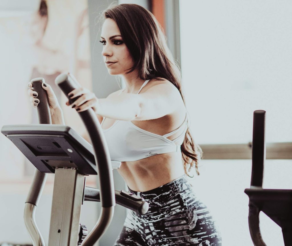 woman doing elliptical machine at gym