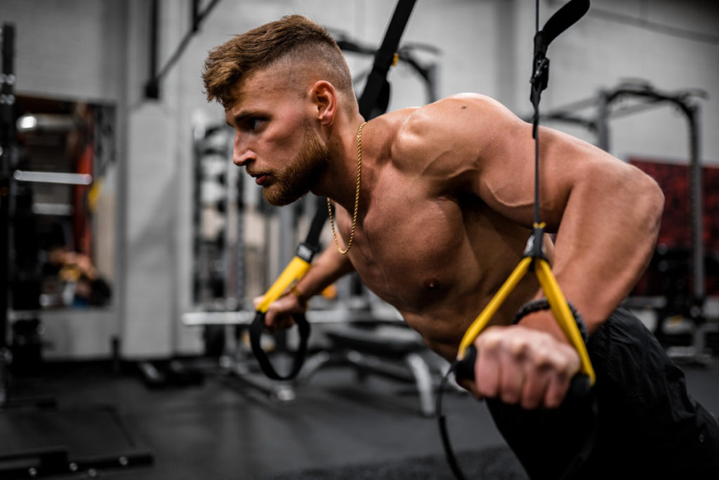 man doing push ups on trx bands for stability training benefits