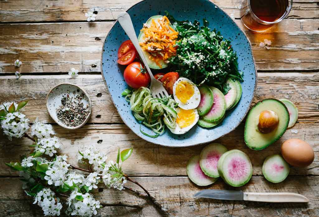 healthy bowl with healthy foods to lose weight avocado egg kale veggies