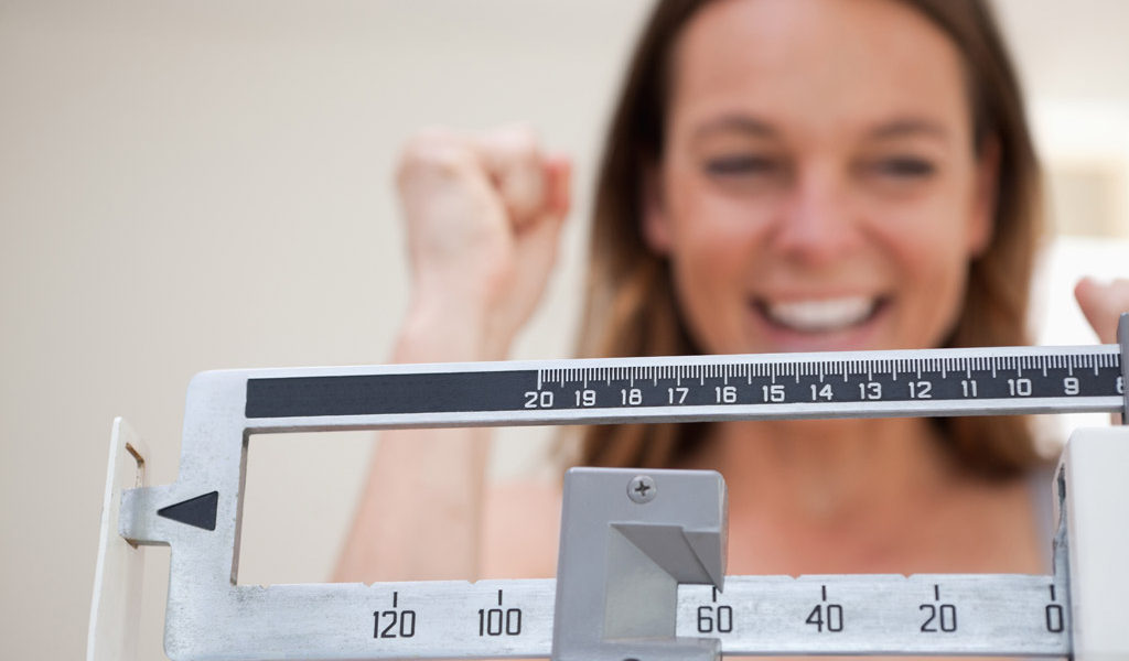 woman trying to lose weight cheering on scale