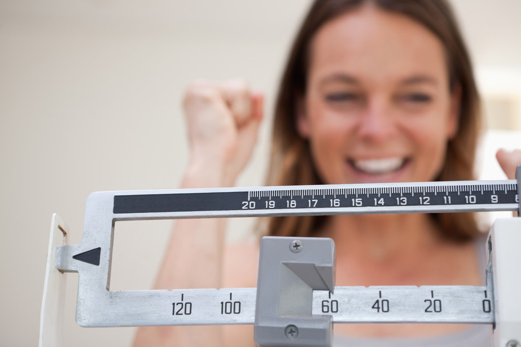 woman trying to lose weight cheering on scale
