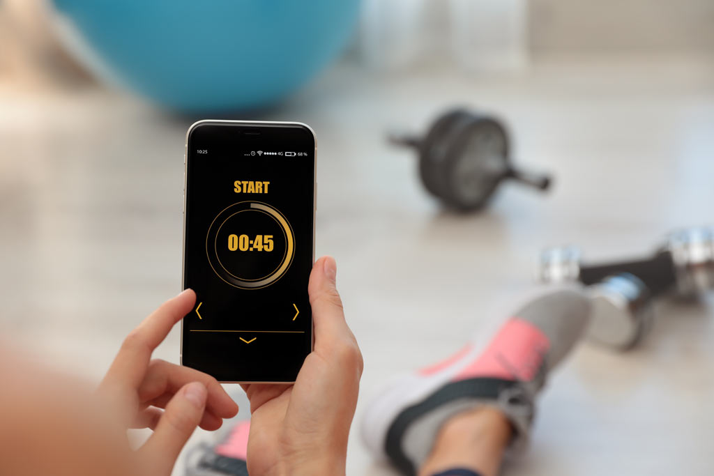 woman setting up hiit format on phone